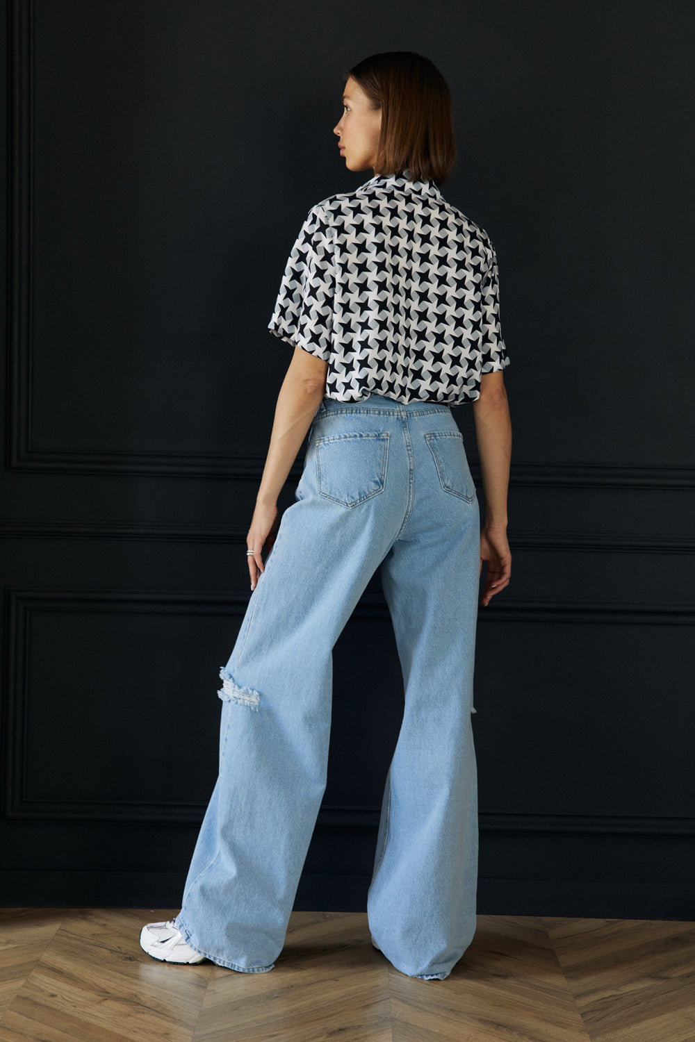 Широкие джинсы с разрезом на колене.